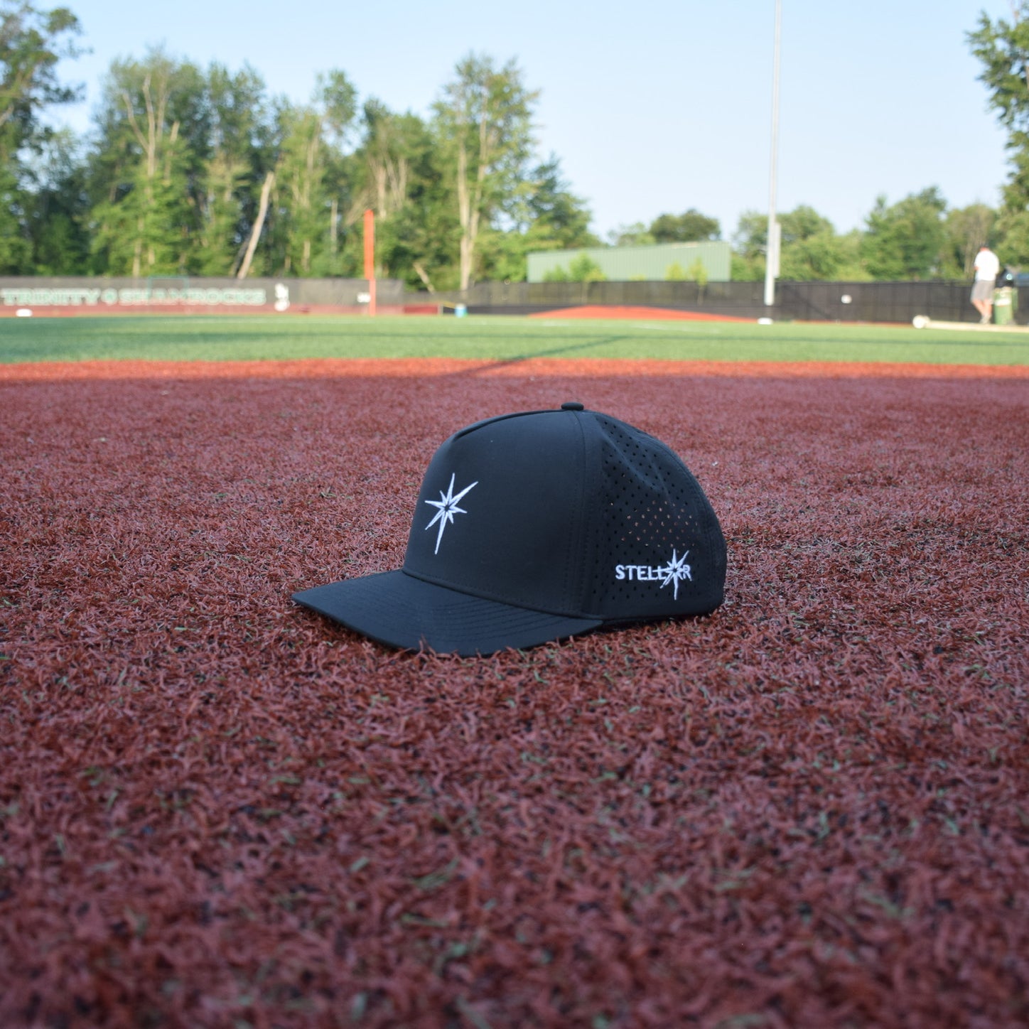 Black cap with a logo on a baseball field