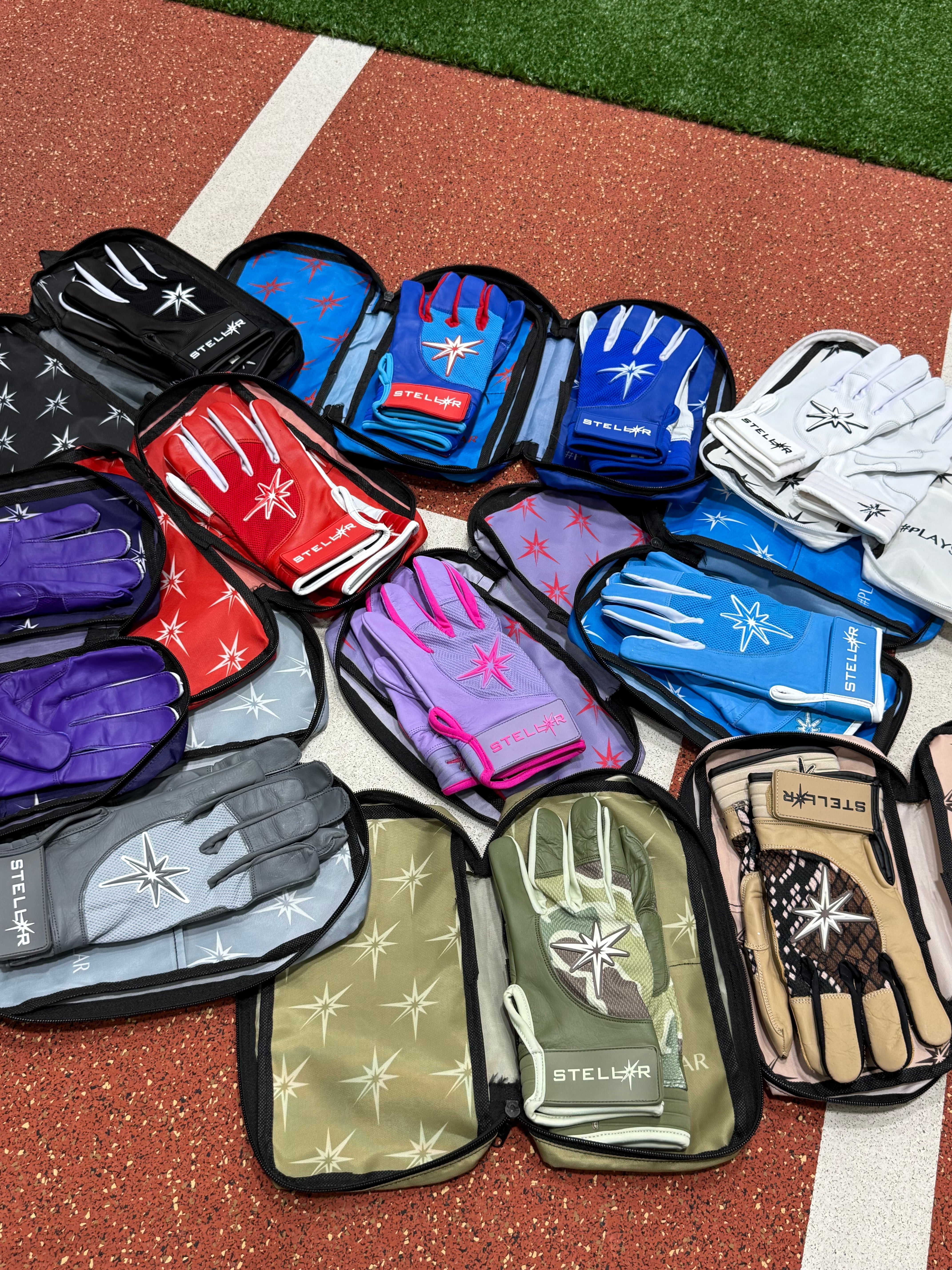 A pair of stylish batting gloves resting on a wooden surface next to baseball bats and a glove.