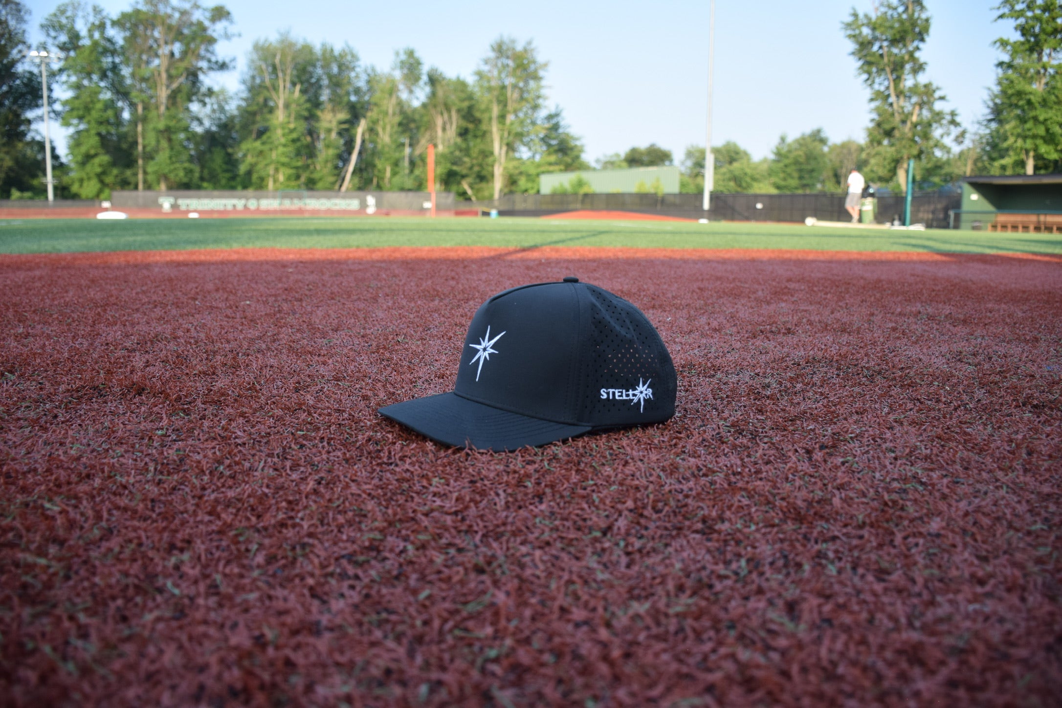 Black cap with a logo on a baseball field