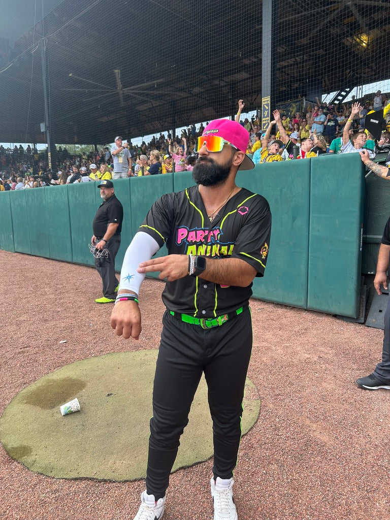 Person in a baseball uniform with colorful accents standing on a baseball field.